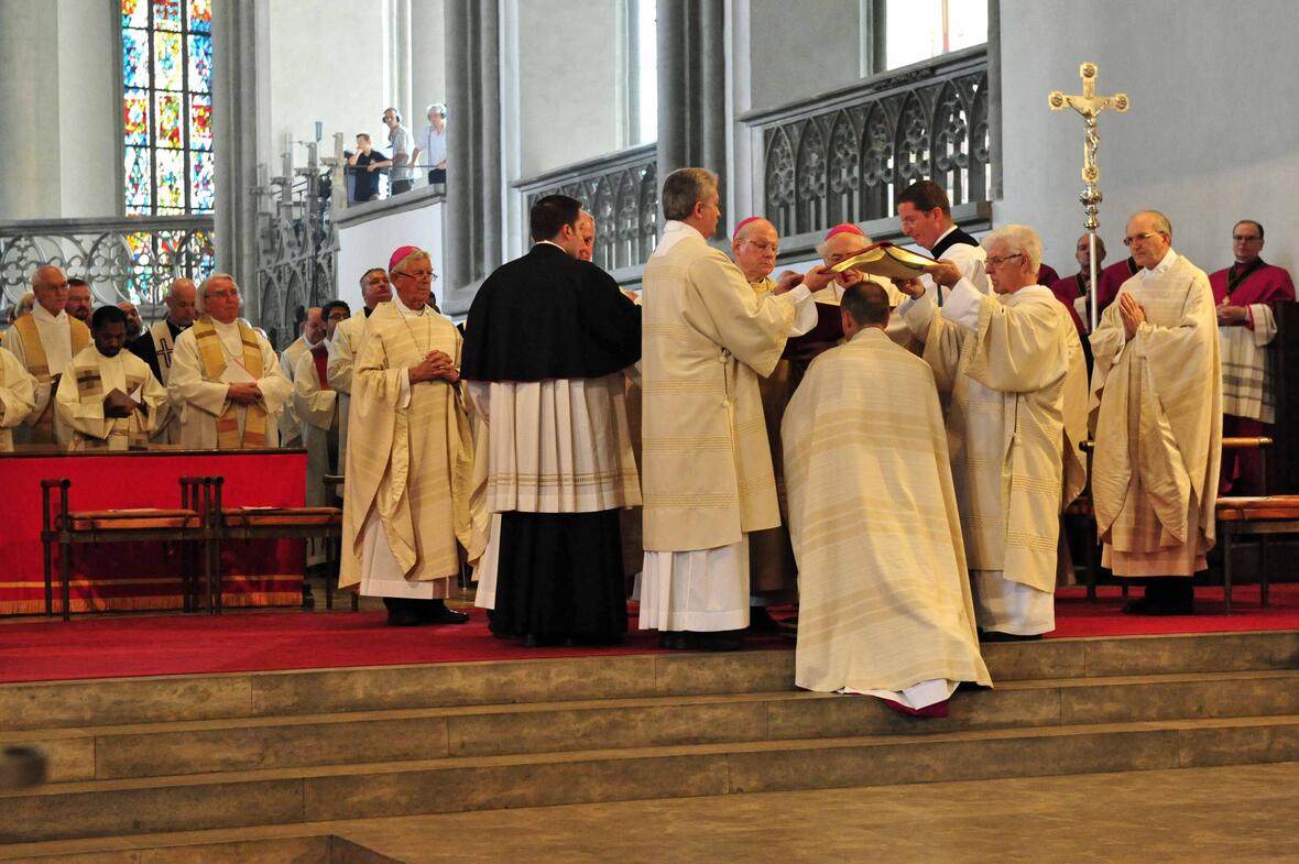 "Bestens behütet" fühlte sich der neue Weihbischof Florian Wörner als das Evangeliar über seinen Kopf gehalten wurde. (Foto: Pressestelle Bistums Augsburg / Markus Kremser)