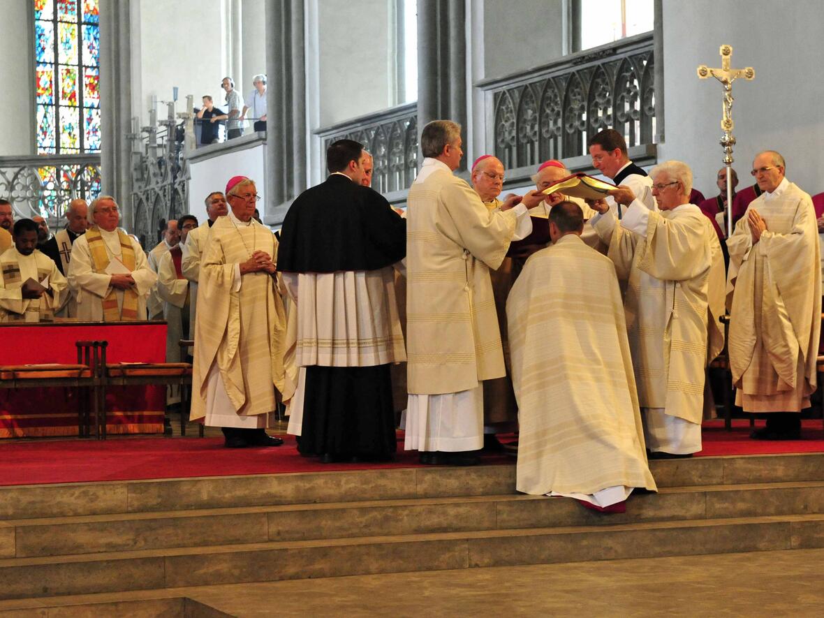 "Bestens behütet" fühlte sich der neue Weihbischof Florian Wörner als das Evangeliar über seinen Kopf gehalten wurde. (Foto: Pressestelle Bistums Augsburg / Markus Kremser)