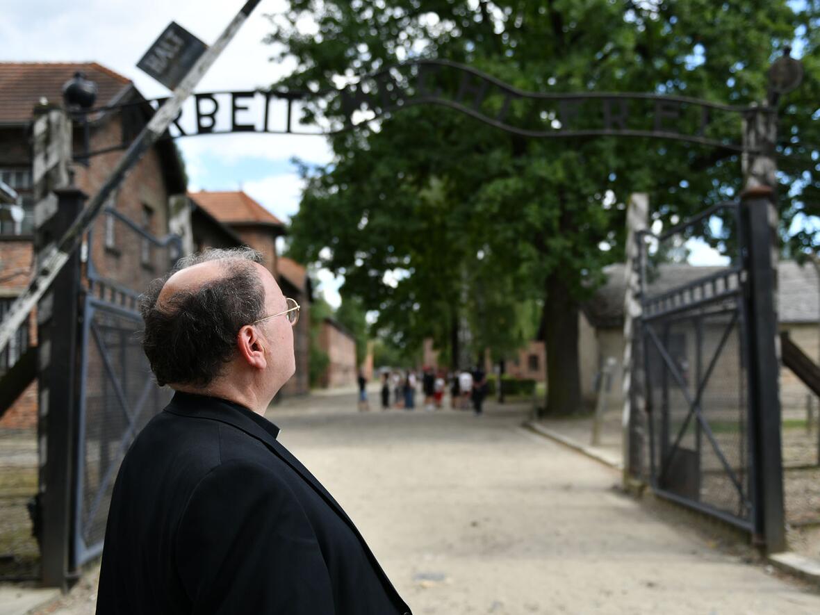 Bischof Bertram vor dem Eingangsbereich des Stammlagers Auschwitz mit dem berüchtigten Spruchband "Arbeit macht frei" (Fotos: Julian Schmidt / pba)