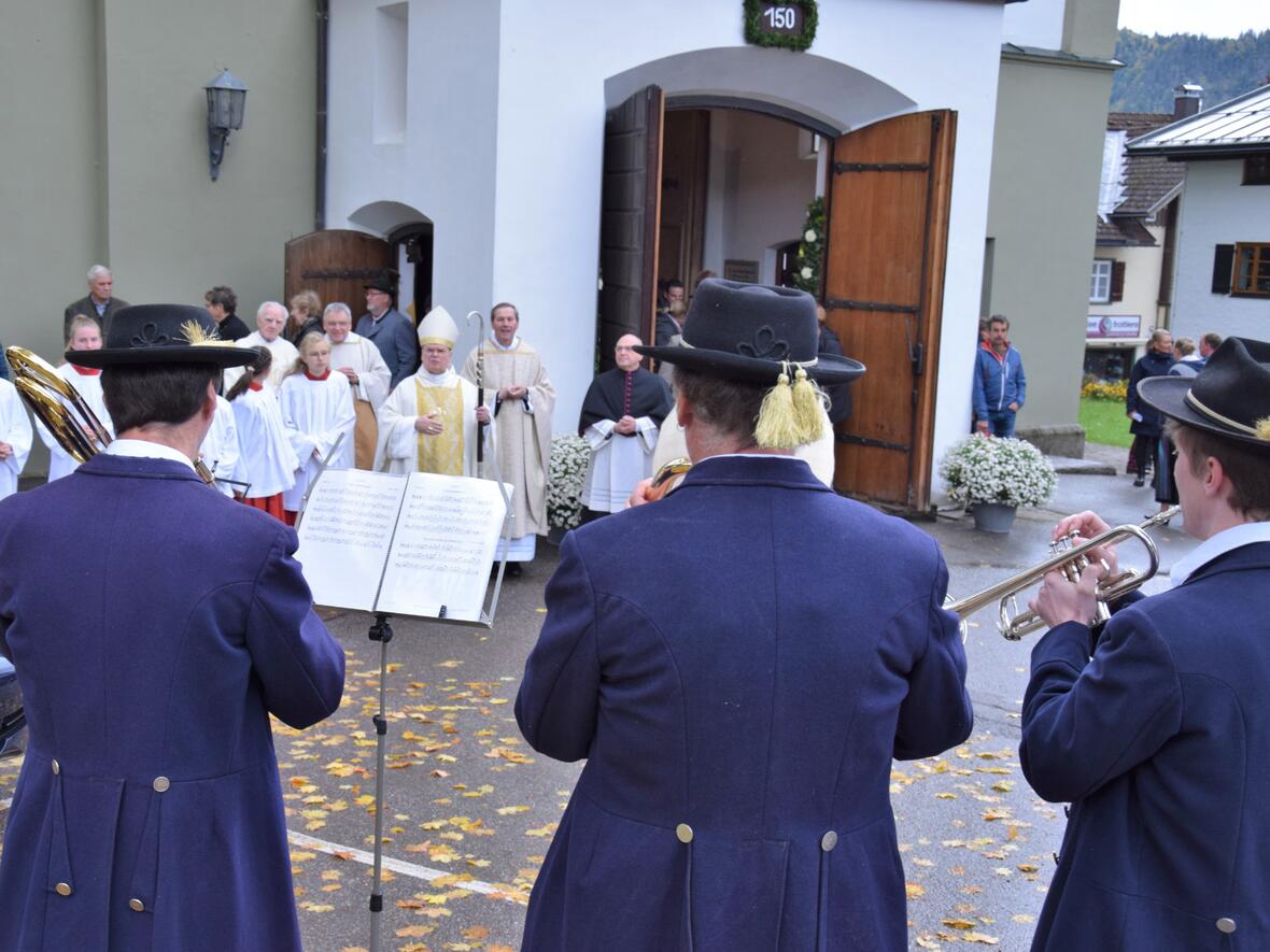 Bischof Dr. Bertram Meier beim Ständchen der Harmoniemusik vor dem Portal der Pfarrkirche St. Johannes Baptist in Bad Hindelang. Rechts neben ihm ist Pfarrer Martin Finkel zu sehen (Fotos: Sabine Verspohl-Nitsche / pdke)