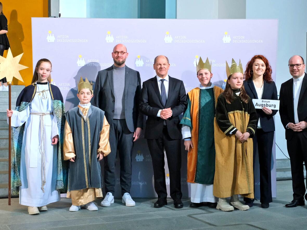 Die Sternsinger Tabea (15), Max (13), Theresa (12) und Til (11) sowie Pastoralassistentin Anna-Maria Maul aus der Pfarrei St. Martin in Wertingen vertraten das Bistum Augsburg am Donnerstagnachmittag beim Sternsinger-Empfang von Bundeskanzler Olaf Scholz zur 65. Aktion Dreikönigssingen. Zum Gruppenfoto mit dem Kanzler stellten sie sich gemeinsam mit Pfarrer Dirk Bingener, Präsident des Kindermissionswerks ‚Die Sternsinger‘, und Domvikar Stefan Ottersbach, Bundespräses des Bundes der Deutschen Katholischen Jugend (BDKJ), im Bundeskanzleramt auf. (Foto: Ralf Adloff/Kindermissionswerk)