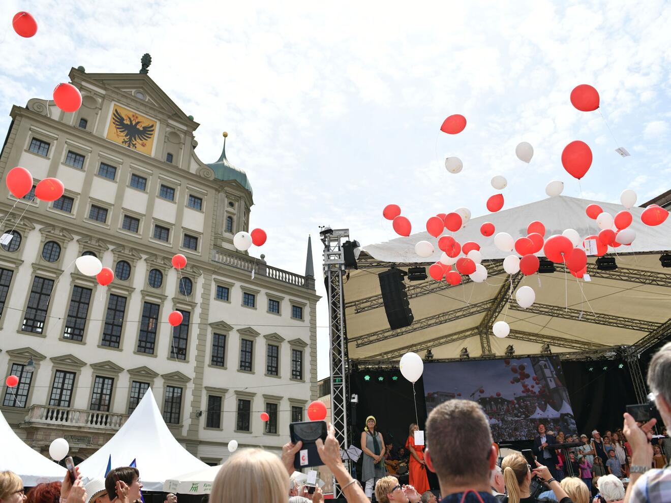 Rot und weiß färbte sich der Himmel über dem Augsburger Rathausplatz beim Auftaktfest für das Ulrichsjubiläum. Die Luftballone waren mit Bitten an den Bistums- und Stadtpatron versehen. (Foto: Maria Rösch / pba)  