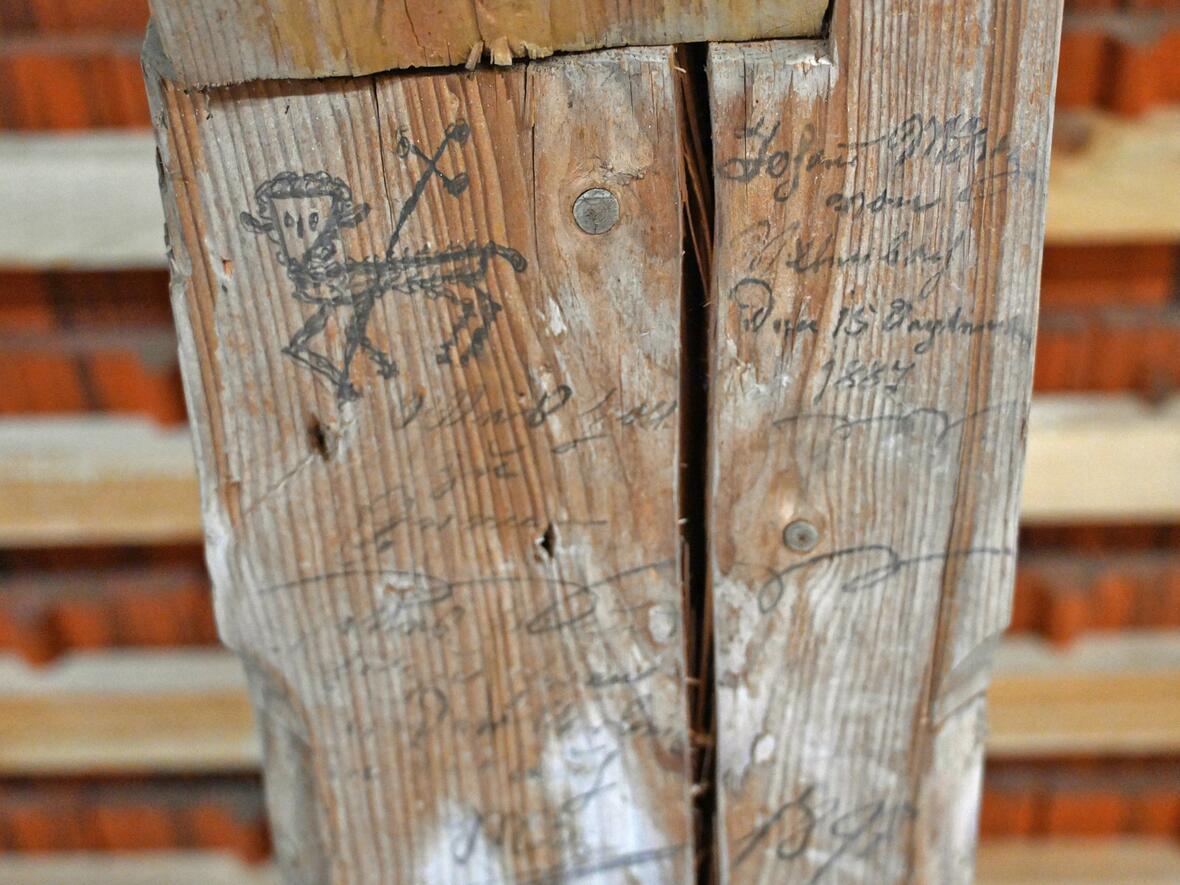 Christliche Graffiti von Handwerkern vergangener Jahrhunderte auf den Dachbalken.