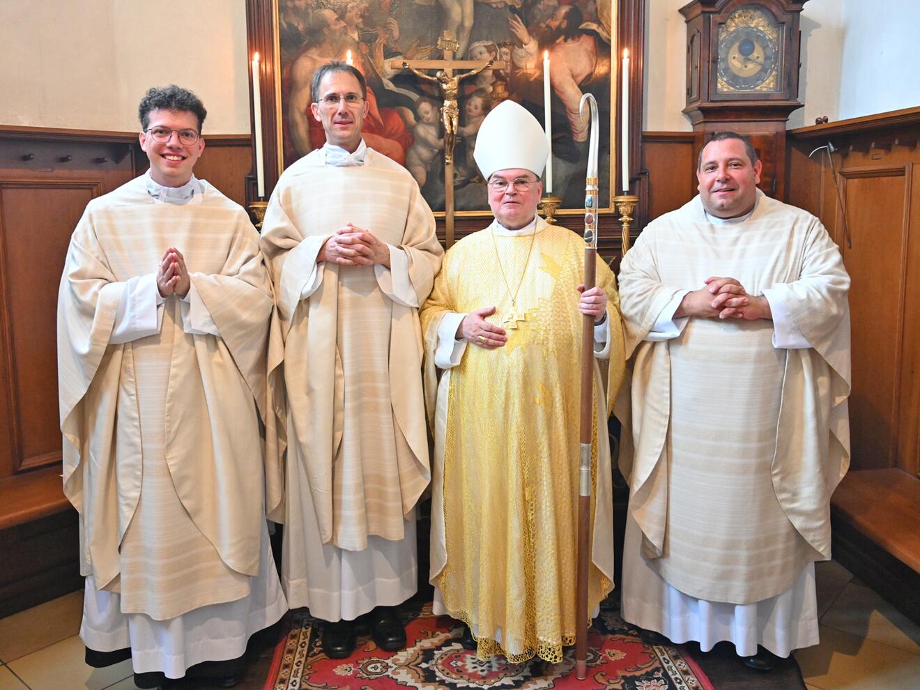Strahlende Neupriester zusammen mit ihrem Weihespender. 