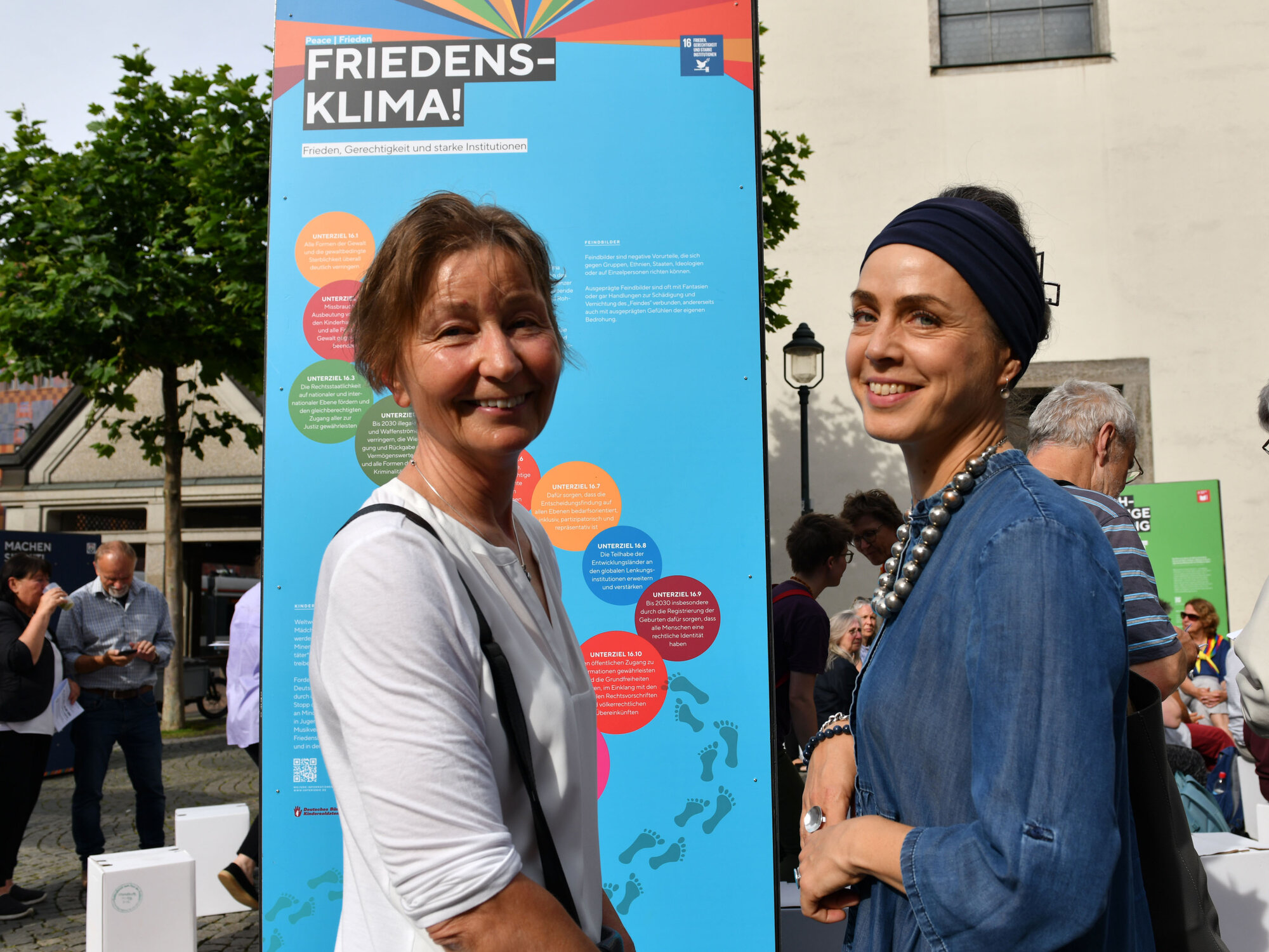 Auf Säulen finden Besucherinnen und Besucher Infos zum Thema "Nachhaltigkeit", wie diese zwei Frauen im Rahmen der Eröffnung.