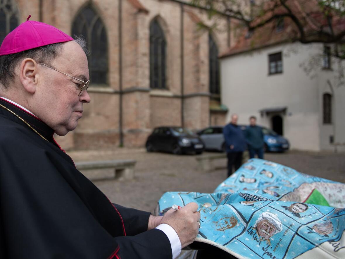 Bischof Bertram trug mit seiner Unterschrift gerne zum guten Zweck bei.