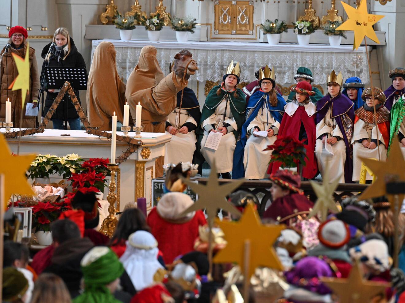 Sternsinger mit Kamel im Altarraum der Pfarrkirche Mariä Himmelfahrt. 