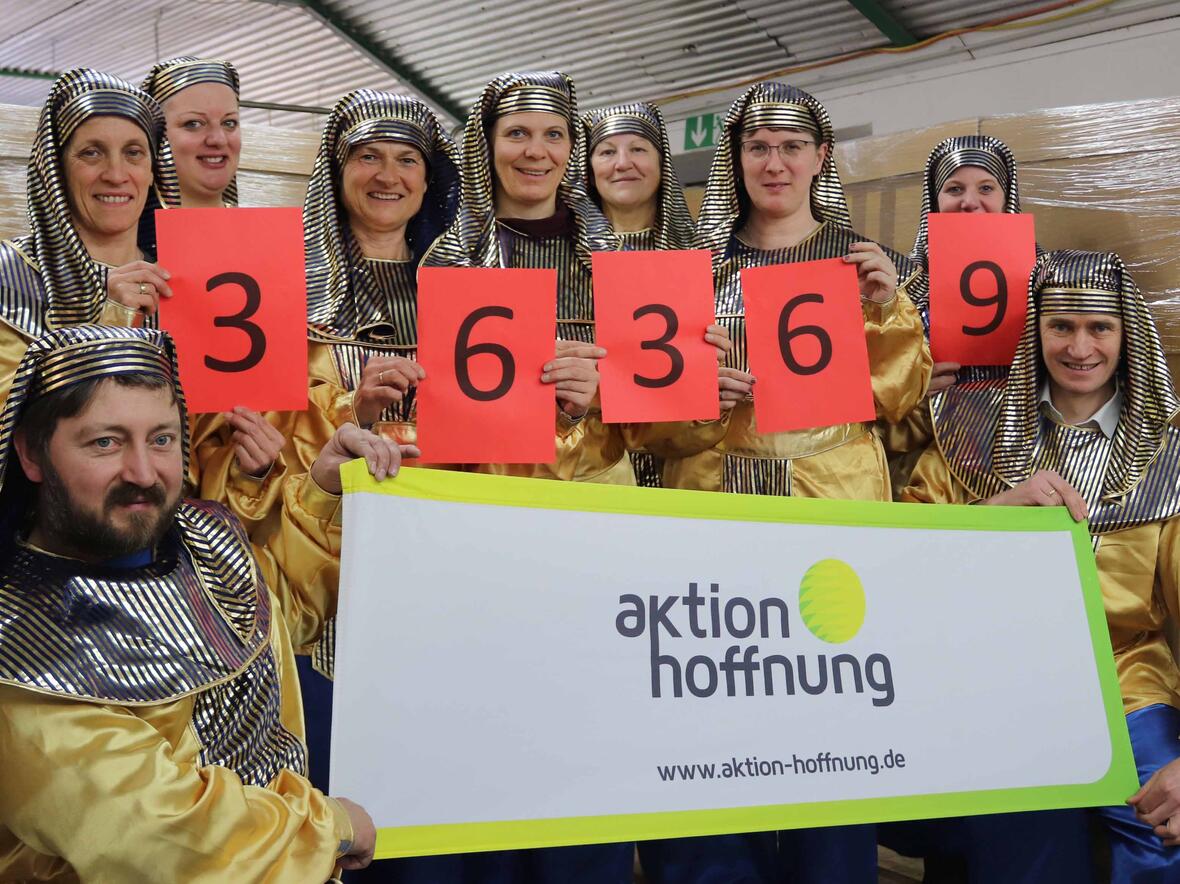 Erfolgreicher Abschluss der Secondhand-Faschingsmärkte: Geschäftsführer Johannes Müller (rechts) und das Team der Sortierung sind dankbar für einen reibungslosen Verlauf aller 44 Faschingsmärkte und präsentieren das diesjährige Ergebnis. (Foto: aktion hoffnung / Karin Stippler)