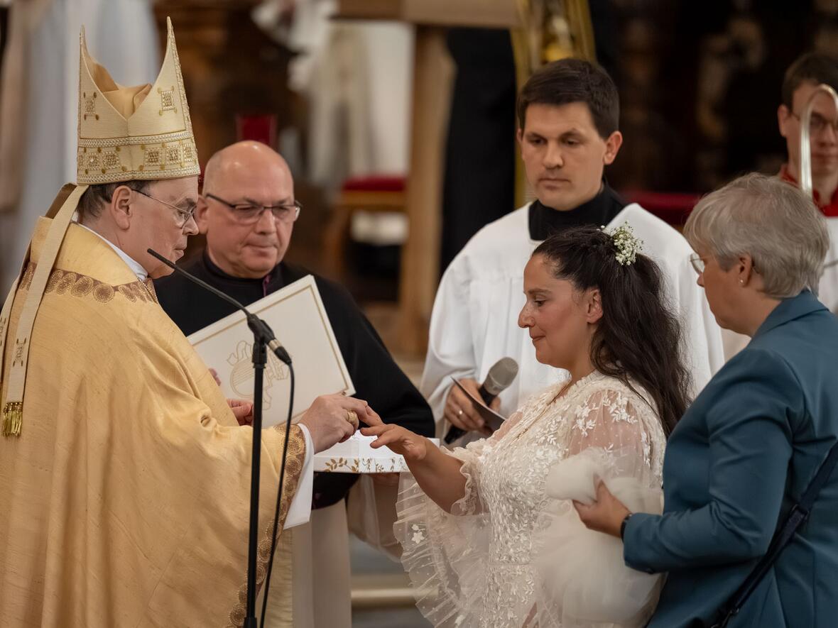 Bischof Bertram steckt der geweihten Jungfrau den Ring als Zeichen ihrer Bindung an Christus an.