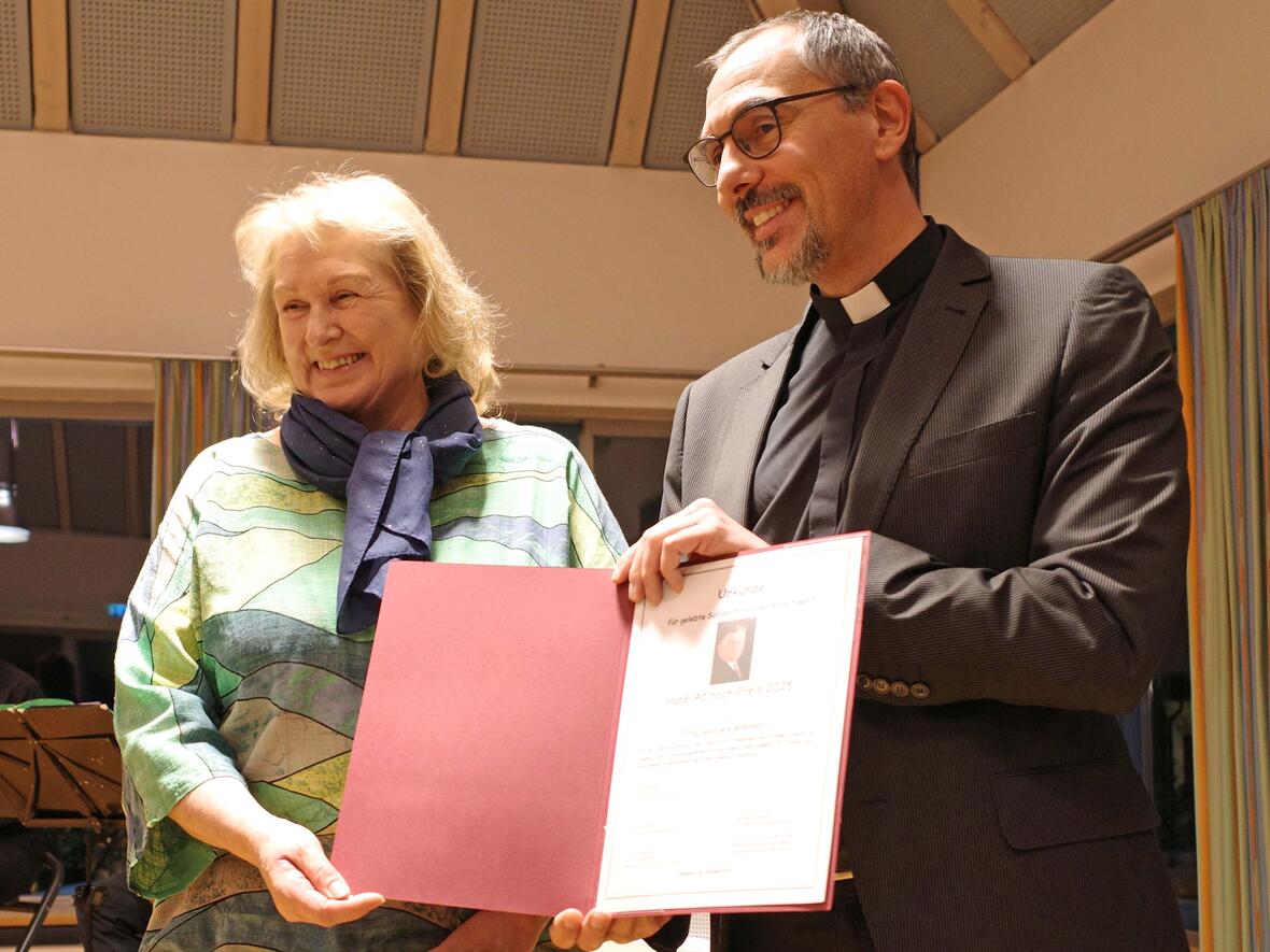 Domvikar Dominik Zitzler überreicht Gabriele Brenner den Adlhoch-Preis. Vorgeschlagen wurde die Preisträgerin von CAJ, KAB und Betriebsseelsorge. (Foto: Georg Steinmetz)
