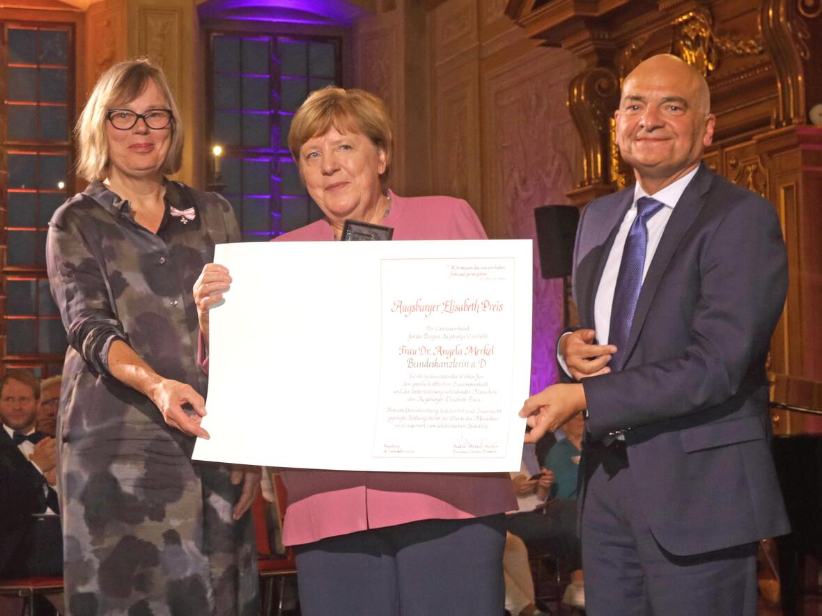 Bundeskanzlerin a.D. Dr. Angela Merkel bekommt im Goldenen Saal des Augsburger Rathauses aus den Händen von Caritas-Präsidentin Welskop-Deffaa und Diözesan-Caritasdirektor Diakon Müller den Elisabethpreis überreicht. (Fotos: Caritas Augsburg / Annette Zoepf)