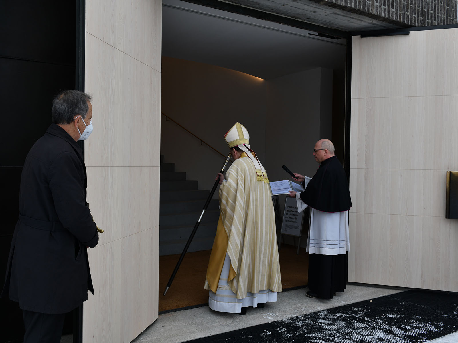 Bischof Bertram bezeichnet den Eingangsbereich mit dem Kreuz.