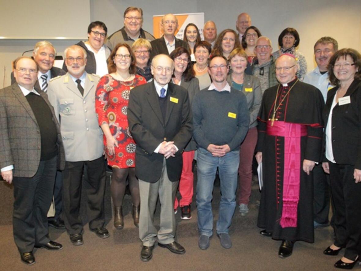 Eingerahmt von Dankenden: Die ausscheidenden Diözesanratsmitglieder Helmut Mangold, Ernst Schmidhuber, Susanne Ahle, Sabine Feldmann, Franz Erlewein, Karin Günter, Otto Kocherscheidt, Engelbert Waldmann, Gertrud Brunner, Barbara Reichhart, Gisela Brandstetter, Karl Dolp, Wolfgang Seidler, Lisa Buchenberg, Wedigunda Zillner, Max Weinkamm (durch Hinzuwahl erneut Mitglied), Ulrike Dreher, Franz Ostermeir, Ursula Kohler, Marcel Rappold (v.l.n.r.) eingerahmt von Prälat Dr. Meier, dem Bischöfl. Beauftragten (ganz links), Bischof Dr. Konrad Zdarsa (rechts) und Vorsitzende Hildegard Schütz (ganz rechts). Foto: Annette Zoepf / pba